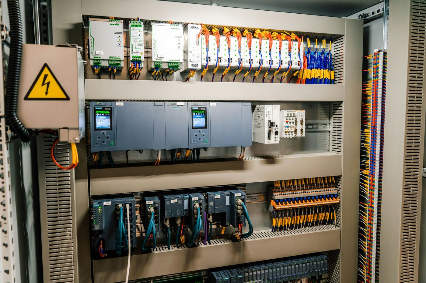 Wnętrze rozdzielnicy sterowniczej: sterowniki PLC, zasilacze, moduły sieciowe i listwy zaciskowe